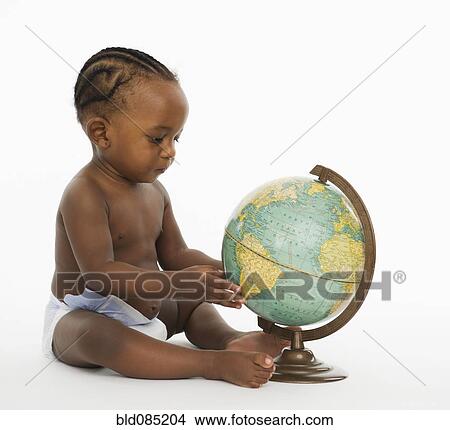 Picture - African American baby looking at globe. Fotosearch
