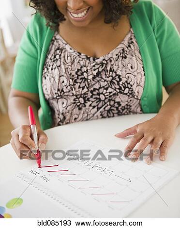 African American woman crossing off days on calendar View Large Photo Image Stock Image - African American woman crossing off days on calendar. Fotosearch