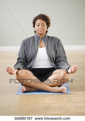Stock Photo - African American woman practicing yoga. Fotosearch