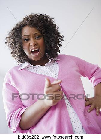 Stock Image - African American woman screaming and pointing her finger. Fotosearch