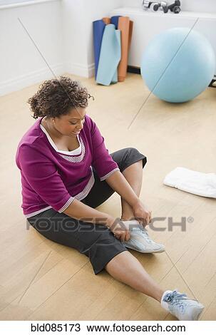 African American woman sitting on floor putting on shoes View Large Photo Image Stock Image - African American woman sitting on floor putting on shoes. Fotosearch