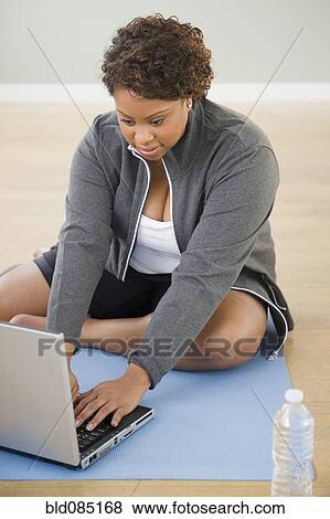 African American woman sitting on floor using laptop View Large Photo Image Stock Photo - African American woman sitting on floor using laptop. Fotosearch