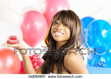 Stock Image - African American woman with birthday presents. Fotosearch