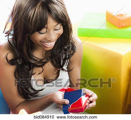 Stock Image - African American woman with birthday present. Fotosearch