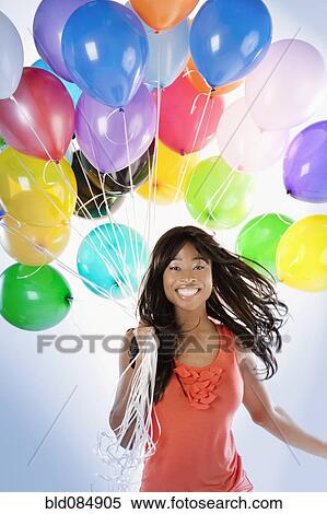 Stock Photography - African American woman with birthday balloons. Fotosearch