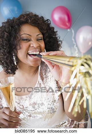African American woman with noise maker and glass of Champagne View Large Photo Image Stock Photography - African American woman with noise maker and glass of Champagne. Fotosearch