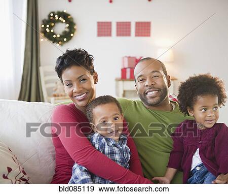 Stock Photo - Black family relaxing on sofa together. Fotosearch
