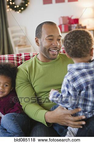 Black father and children relaxing on sofa View Large Photo Image Stock Photo - Black father and children relaxing on sofa. Fotosearch