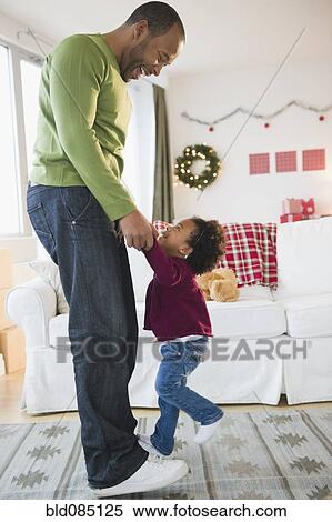 Black father and daughter dancing in living room View Large Photo Image Stock Photography - Black father and daughter dancing in living room. Fotosearch