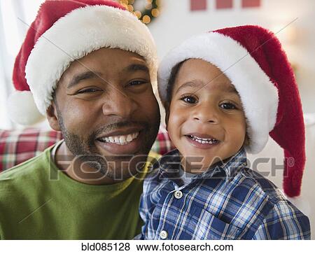 Black father and son wearing Santa hats View Large Photo Image Stock Photo - Black father and son wearing Santa hats. Fotosearch