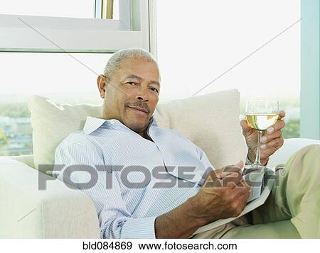 Black man drinking wine and reading book View Large Photo Image Stock Photo - Black man drinking wine and reading book. Fotosearch