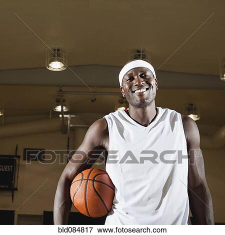 Black man holding basketball on basketball court View Large Photo Image Stock Photo - Black man holding basketball on basketball court. Fotosearch