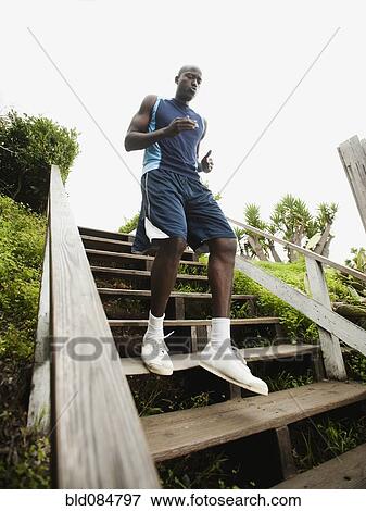 Stock Photo - Black man running down stairs for exercise. Fotosearch