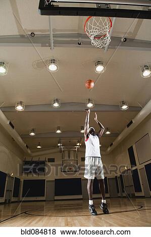 Black man shooting basketball on basketball court View Large Photo Image Stock Photo - Black man shooting basketball on basketball court. Fotosearch