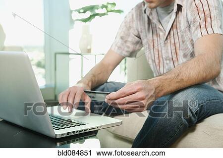 Stock Image - Caucasian man shopping online with credit card. Fotosearch