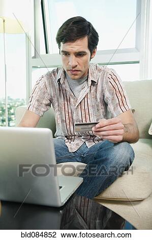Stock Image - Caucasian man shopping online with credit card. Fotosearch