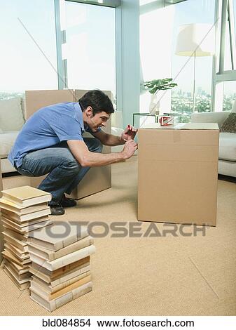 Caucasian man writing on cardboard packing box View Large Photo Image Picture - Caucasian man writing on cardboard packing box. Fotosearch