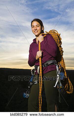 Stock Photo - Caucasian woman preparing for rock climbing. Fotosearch