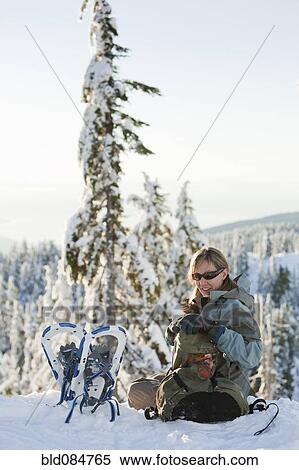 Stock Photography - Caucasian woman snowshoeing in remote area taking break. Fotosearch