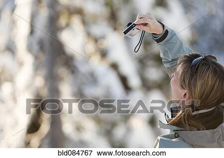 Stock Photo - Caucasian woman taking photograph with digital camera. Fotosearch