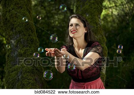 Caucasian woman trying to catch bubbles in her hands View Large Photo Image Stock Image - Caucasian woman trying to catch bubbles in her hands. Fotosearch