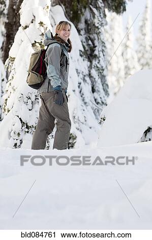 Stock Image - Caucasian woman walking in snow. Fotosearch