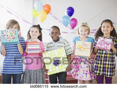 Stock Photography - Children at birthday party holding gifts. Fotosearch