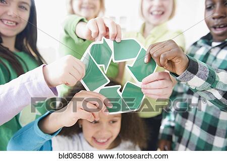 Stock Photo - Children holding green recycling symbol. Fotosearch
