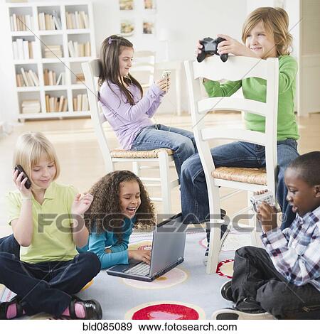 Stock Photo - Children playing with various technology together. Fotosearch