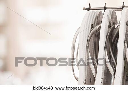 Close up of flip flops hanging on rack View Large Photo Image Stock Image - Close up of flip flops hanging on rack. Fotosearch