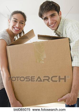 Couple carrying cardboard box together View Large Photo Image Stock Photography - Couple carrying cardboard box together. Fotosearch