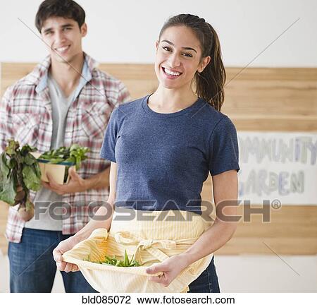 Stock Image - Couple carrying vegetables together. Fotosearch