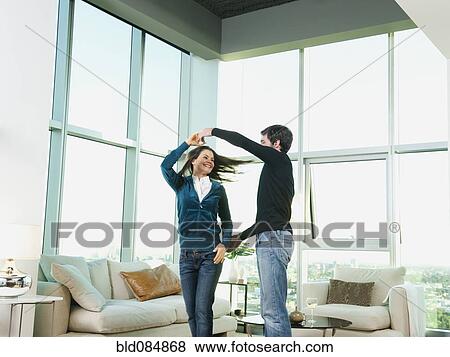 Couple dancing together in living room View Large Photo Image Stock Photo - Couple dancing together in living room. Fotosearch