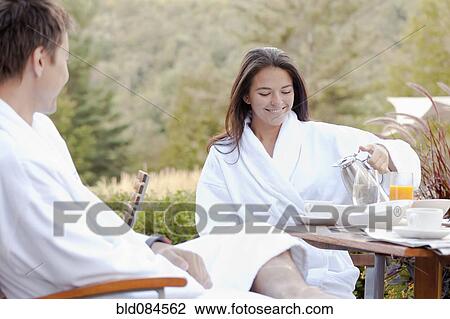 Stock Image - Couple enjoying breakfast on outdoor patio. Fotosearch