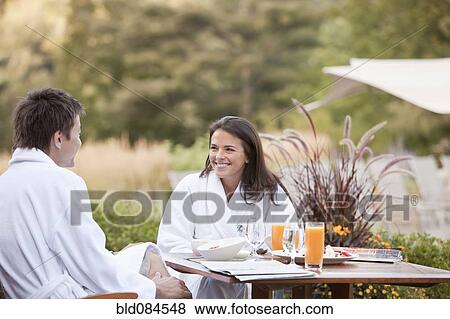 Stock Photo - Couple enjoying breakfast on outdoor patio. Fotosearch