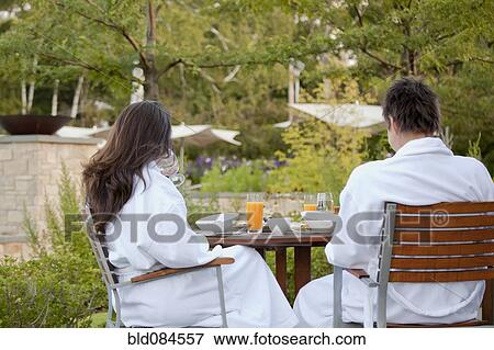 Stock Photo - Couple enjoying breakfast on outdoor patio. Fotosearch