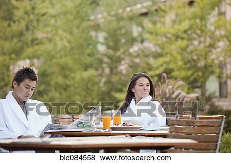 Stock Photo - Couple enjoying breakfast on outdoor patio. Fotosearch