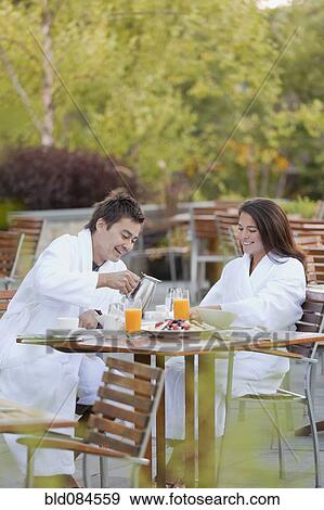 Stock Photo - Couple enjoying breakfast on outdoor patio. Fotosearch