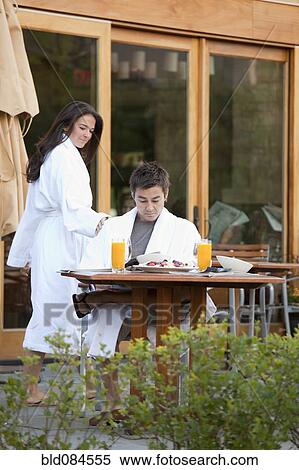 Couple enjoying breakfast on outdoor patio View Large Photo Image Stock Photography - Couple enjoying breakfast on outdoor patio. Fotosearch
