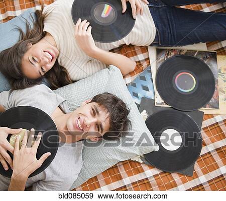 Stock Photo - Couple listening to vinyl records together. Fotosearch