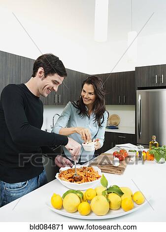 Couple making dinner together in kitchen View Large Photo Image Stock Image - Couple making dinner together in kitchen. Fotosearch