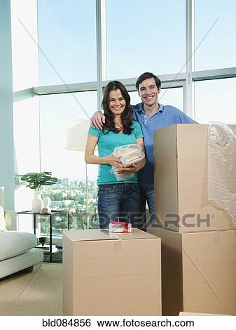 Stock Photograph - Couple packing cardboard boxes together. Fotosearch