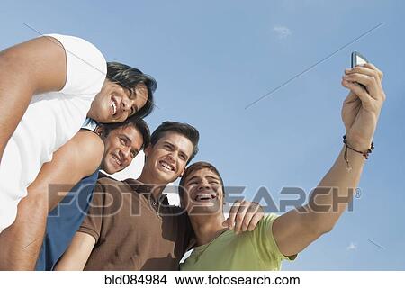 Friends taking self-portrait with cell phone View Large Photo Image Picture - Friends taking self-portrait with cell phone. Fotosearch