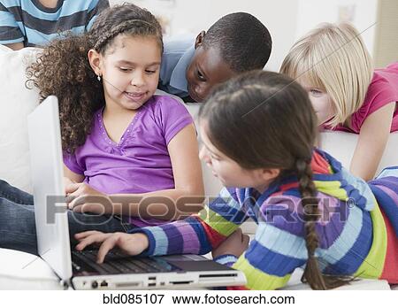 Stock Photo - Friends using laptop together. Fotosearch