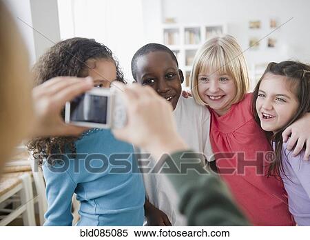 Girl taking photograph of friends with digital camera View Large Photo Image Stock Photography - Girl taking photograph of friends with digital camera. Fotosearch