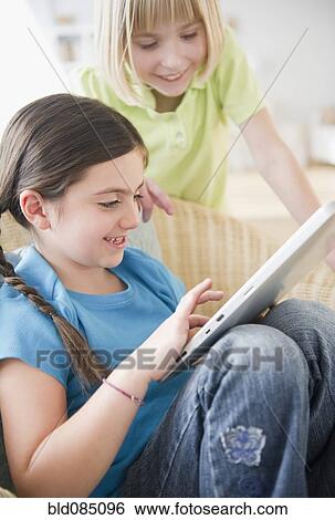 Girls using digital tablet together View Large Photo Image Stock Photograph - Girls using digital tablet together. Fotosearch