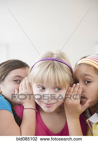 Stock Image - Girls whispering together. Fotosearch