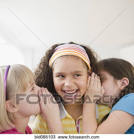 Stock Image - Girls whispering together. Fotosearch