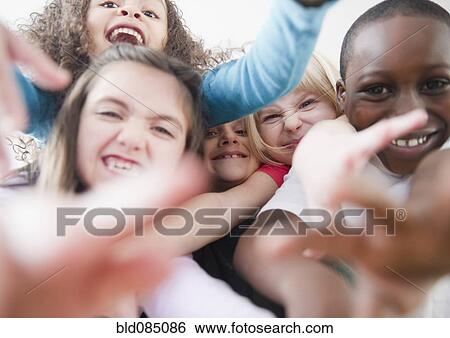 Stock Photograph - Grinning children reaching toward camera. Fotosearch