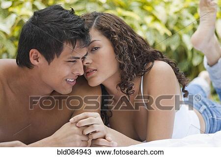 Hispanic couple laying on ground together View Large Photo Image Stock Image - Hispanic couple laying on ground together. Fotosearch